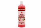 A plastic bottle of Nature's Specialties Spiced Cranberry pet shampoo, filled with a deep pink-red liquid, on a solid white background.