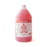 Pink bottle of 'Cherry Blossom Silky' shampoo with a label on a white background