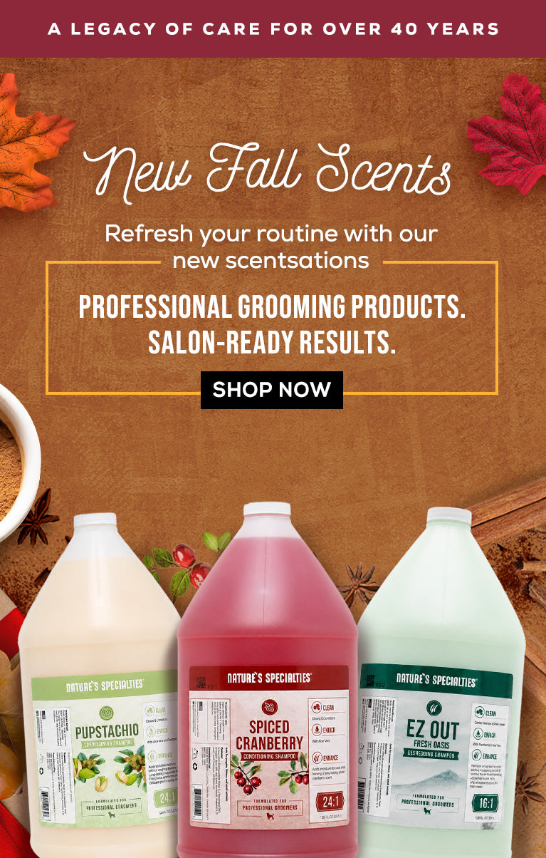 Promotional banner for Nature's Scents fall grooming products, featuring three large plastic jugs of grooming shampoo in white, pink, and mint green, set against a rustic brown background with autumn leaves and text reading 'New Fall Scents'.